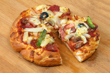 Pizza beef chicken peperoni cheese chilli capsicum onion olive on wooden board