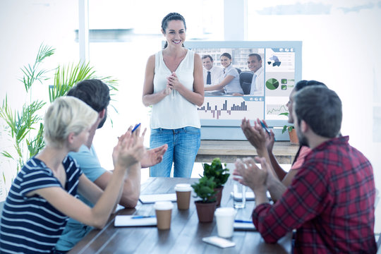 Colleagues clapping hands in a meeting against white background with vignette