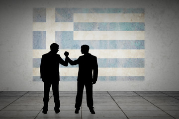 Silhouettes shaking hands against greece flag in grunge effect