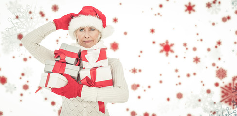 Festive woman holding gifts against snowflake pattern