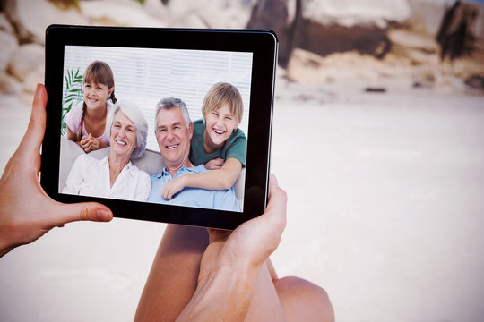 Composite image of grandchildren and grandparents sitting on couch