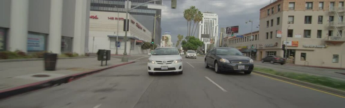 Rear view of a Driving Plate: Car travels on Wilshire Boulevard from Dunsmuir Avenue to Fairfax Avenue in Los Angeles, California.