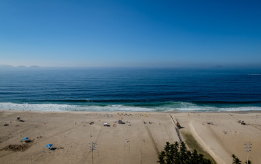view of Copacabana beach during early morning, taken from the rooftop of a hotel, some slight fog can be seen on the blue sky. Rio de Janeiro, Brazil