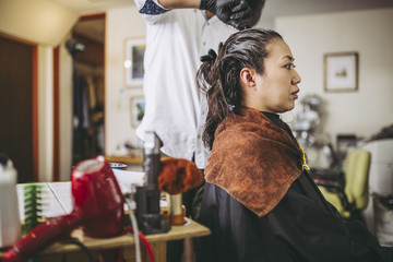 美容院で髪を綺麗にしてもらう女性
