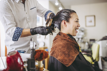 美容院で髪を綺麗にしてもらう女性