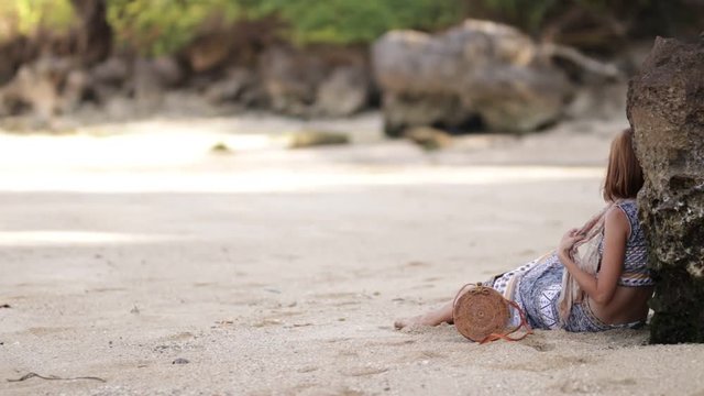 Woman with fashionable stylish nude rattan bag on the beach. Tropical island of Bali. Handmade Rattan eco handbag HD footage.