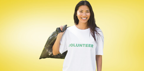 Team of volunteers picking up litter in park against yellow vignette
