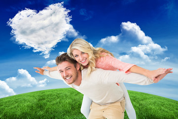 Handsome man giving piggy back to his girlfriend against cloud heart