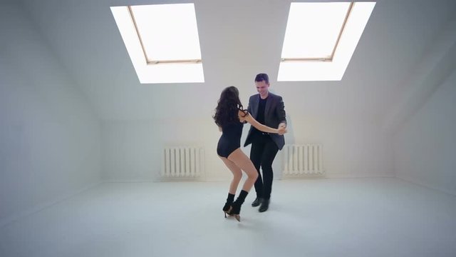 Young couple dancing under Latin music. Bachata or merengue or salsa.