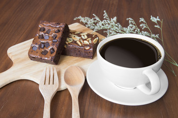 Closeup of cup of black coffee and brownies on a wooden table