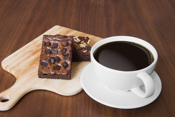 Closeup of cup of black coffee and brownies on a wooden table