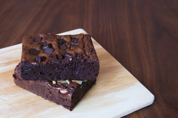 Closeup of cup of black coffee and brownies on a wooden table