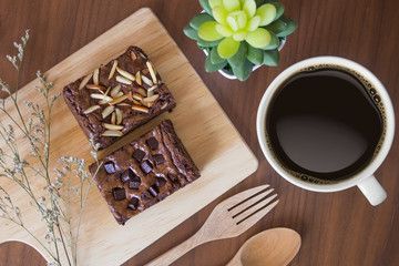 Closeup of cup of black coffee and brownies on a wooden table