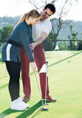 Obraz premium Golf player explaining to woman to play golf