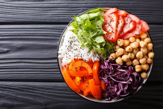 Delicious healthy buddha bowl with fresh vegetables, chickpeas and rice close-up. Horizontal top view