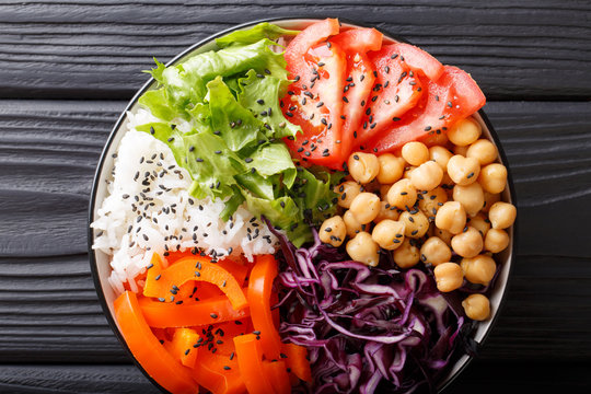 Rice and spicy chickpea vegetable vegetarian buddha bowl. Healthy food concept. Horizontal top view