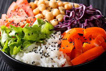 Delicious healthy buddha bowl with fresh vegetables, chickpeas and rice close-up. horizontal