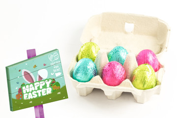Easter egg hunt sign against carton of easter eggs