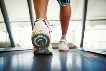 Man walking on the treadmill against fitness interface