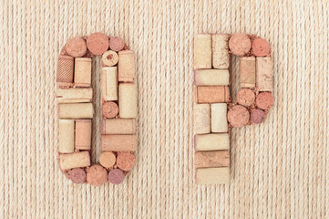 Alphabet letter O and P made of wine corks on jute rope background