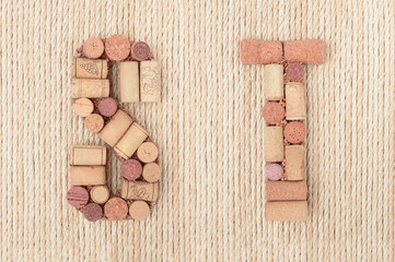 Alphabet letter S and T made of wine corks on jute rope background