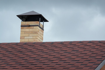 Chimney on the roof of the house. Beauty and comfort. The buildings.