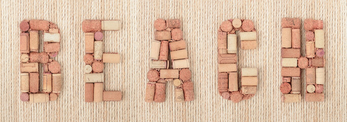Word BEACH made of wine corks on jute rope background. Banner