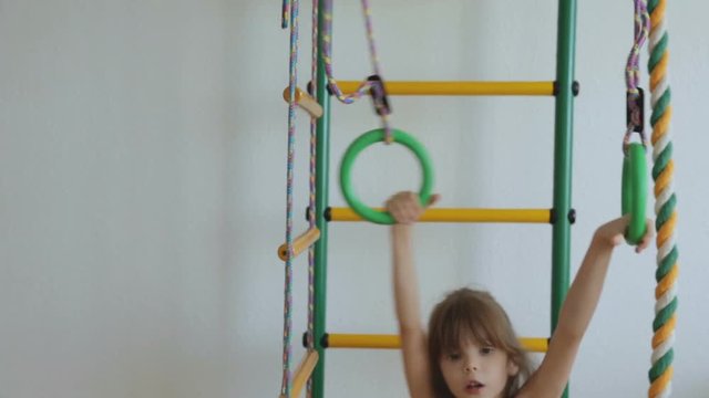 Little girl on wall bars