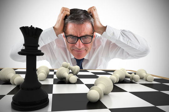Composite image of stressed businessman touching his head with chessboard