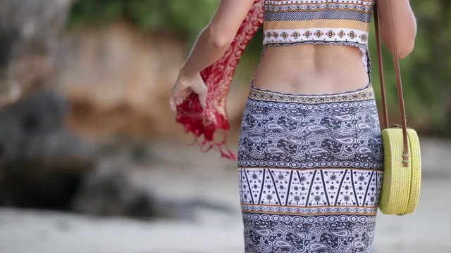 Woman with fashionable stylish rattan bag on the beach. Tropical island of Bali. Handmade Rattan eco handbag HD footage.