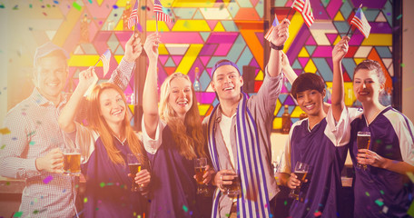 Fototapeta premium Portrait of friends holding American flag in party against flying colours