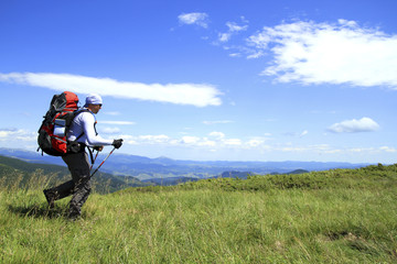 Summer hike in the mountains with a backpack and tent.