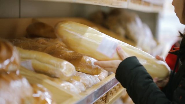 Woman choosing bread at shop