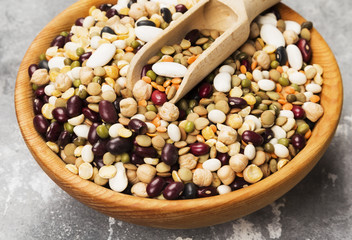 Assortment of beans (red lentil, green lentil, chickpea, peas, red beans, white beans, mix beans, mung bean) on gray background