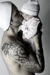 Jeune père séduisant embrassant son bébé
