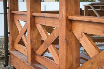 Fototapeta na wymiar New treated pine handrails on the gazebo fencing. Building.