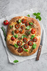 italian bread focaccia with tomatoes, basil and sea salt