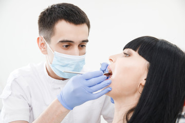 Young woman at reception and examination of teeth by male dentist. Medical Clinic.