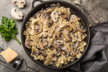 farfalle pasta with champignon mushrooms and garlic creamy sauce on pan