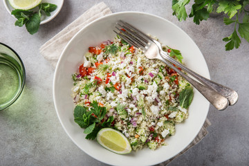 couscous and vegetables salad with feta cheese in white bowl