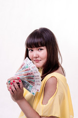 Happy brunette girl in yellow dress holding money