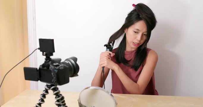 Woman making hair with taking video with digital camera