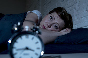 Young beautiful woman lying in bed late at night suffering from insomnia trying to sleep