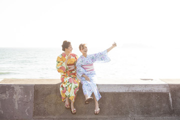 海辺で記念撮影をしている浴衣女性たち