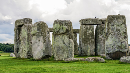 Iconic Stonehenge historial site against clouds and vibrant grass