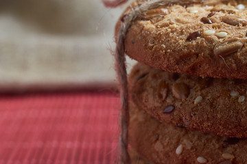 Savory cookies sprinkled with sesame seeds, sunflower on table and burlap background