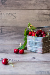 organic cherries freshly picked in a metal box on wooden background 