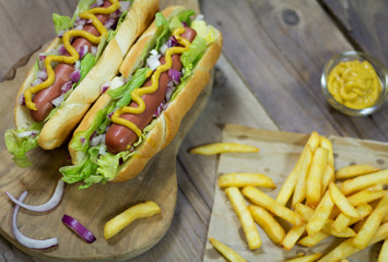 Hot dog and French fries on a wooden table. Fast food. Close up