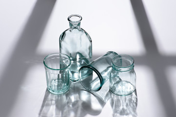 close up view bottle with water and empty glasses on white tabletop