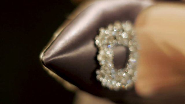 women's shoes clad feet with glittering stones at light